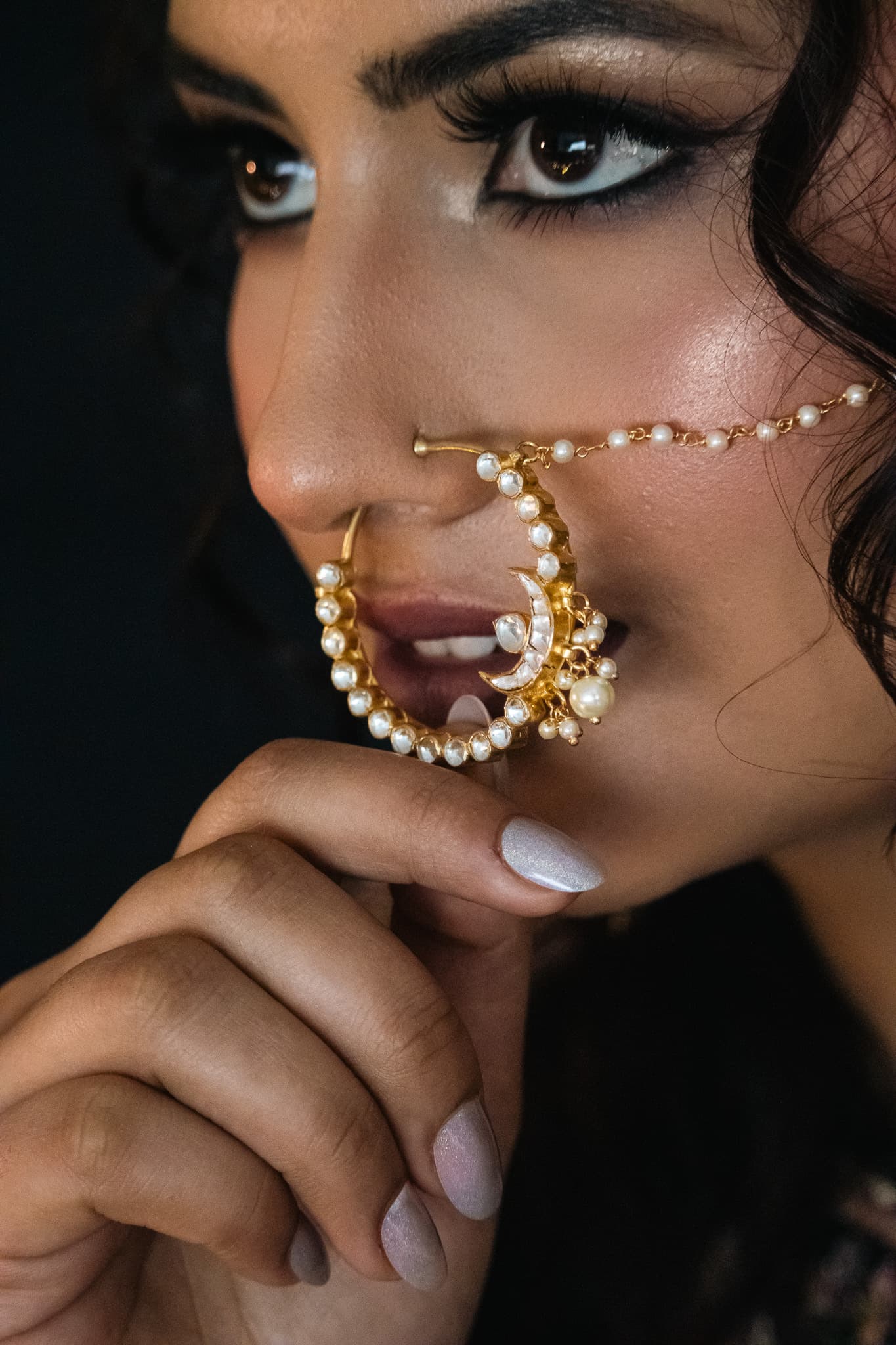 Bride with radiant, long-lasting bridal makeup and gold pearl nath