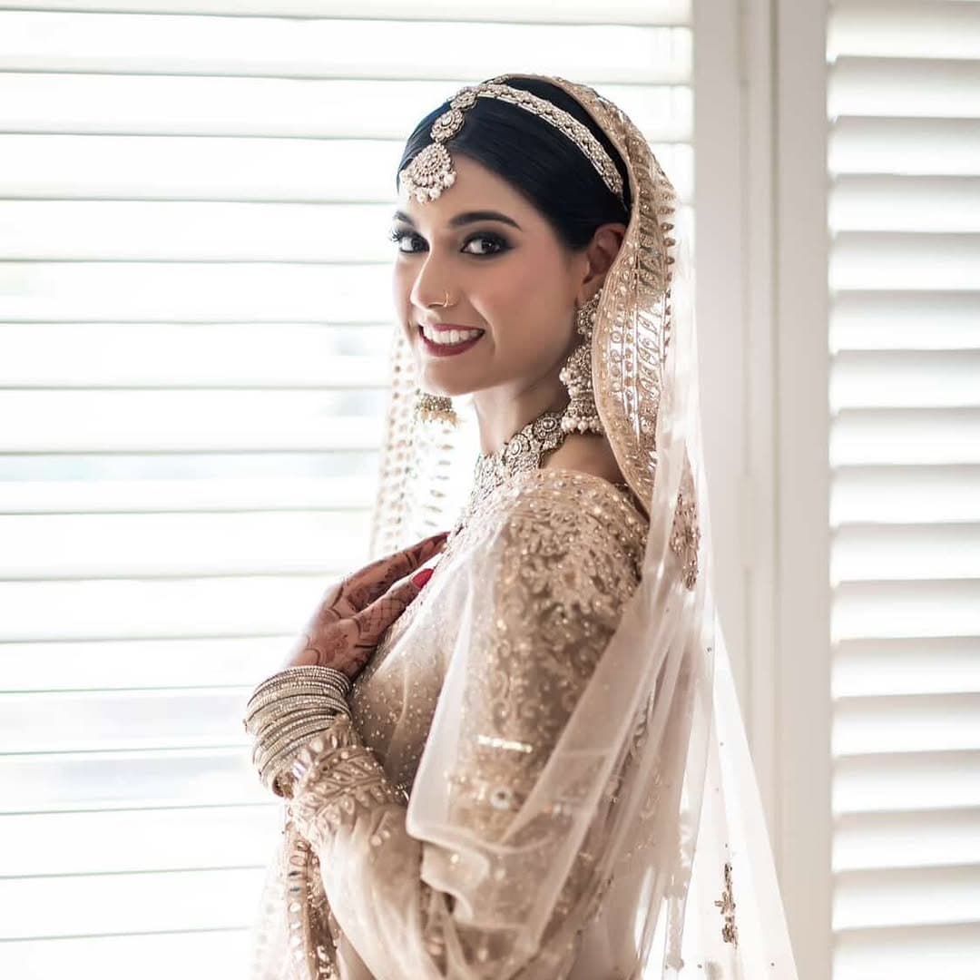 Bride in an ivory bridal gown by the window
