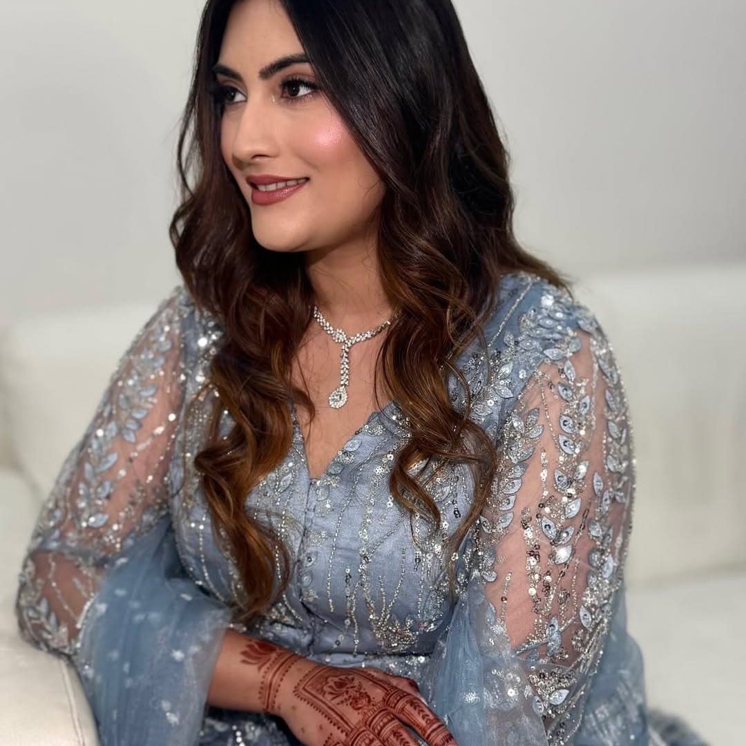 Bride in a dusty-blue embellished outfit with henna